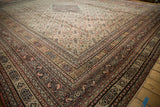 Angled view of an antique Doroksh carpet's stepped corner and complex border with blush and bronze tones.