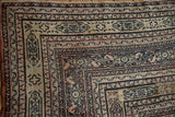 Time-softened patina and low pile on the intricate border of an antique Persian Doroksh carpet corner.