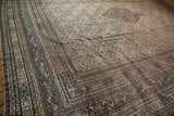 Storied patina and low pile texture across the surface of an antique hand-knotted Doroksh carpet.