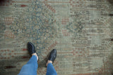 Distressed antique Bijar carpet pile showing Herati motif with faded terracotta and dusty teal.