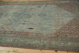 Distressed antique Bijar carpet, even wear revealing Herati motifs, faded blue field, brick red border.