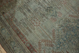 Faded dusty teal and brick red motifs with distressed texture on antique Bijar rug.