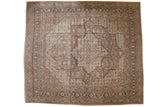 Distressed vintage Tabriz carpet with a scalloped medallion and floral border in tones of rust, ivory, and brown.