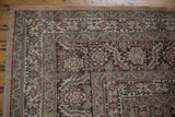 Corner view of a vintage Tabriz carpet, detailing the serrated leaf border and time-softened even wear.