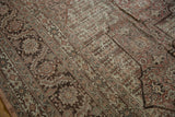 Angled detail of a distressed Tabriz carpet's intricate floral border and even, low-pile texture.
