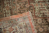 Corner detail of a distressed Tabriz carpet showing its hand-knotted back and orange selvage.