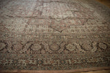 Low angle on the intricate floral and serrated leaf border of a distressed vintage Tabriz carpet.