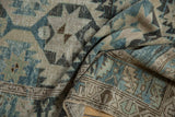 Textural view of distressed vintage Persian runner with muted blue, beige, brown patterns.