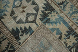 Distressed Northwest Persian runner reveals its primitive geometric pattern and hand-knotted foundation.