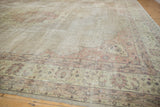 Distressed vintage Sparta carpet corner with scalloped spandrel and faded floral patterns in blush and beige.