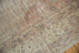 Worn texture of a distressed Turkish Sparta rug corner, with muted blush and beige.