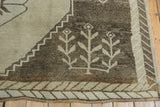 Distressed Kars carpet showing primitive beige floral motifs and stepped geometric border.