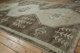 Distressed Kars carpet corner, primitive zigzag border, and brown meandering vine motif.