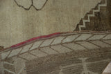 Distressed beige Kars carpet pile, red warps, and woven geometric brown foundation.