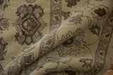 Close-up of folded Egyptian Agra carpet revealing beige, silver, chocolate floral patterns.