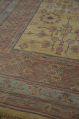 Dusty gold field with pomegranate vases, abrash, and border in pale red, mauve, silver tones.