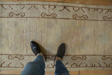 Distressed beige Pakistani Khotan runner with subtle abrashes and chocolate brown ram's horn border.