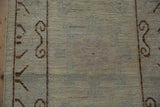 Distressed Khotan runner's scrolling brown border with visible knot heads.
