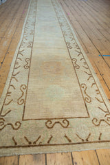 Distressed Pakistani Khotan runner pile and chocolate brown scrolling ram's horn border detail.