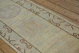 Distressed beige runner showing faded mauve, mint, and chocolate brown ram's horn border.