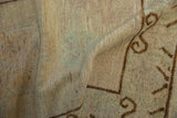 Detail of the hand-knotted foundation, revealing the beige and brown weave with hints of green.