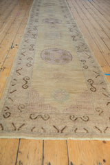 Distressed Pakistani Khotan runner, showing a mauve roundel medallion and chocolate brown border.