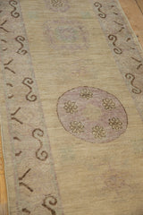 Distressed Khotan design rug runner, faded mauve roundel and scrolling brown border motif.