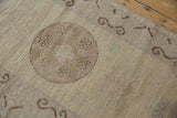 Distressed texture of a beige Khotan rug pile with subtle abrash and faint foundation.