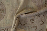 Distressed beige Khotan design runner showing ram's horn border motif, faint mauve.