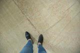 Vintage distressed Oushak rug with softly worn beige, ivory surface and faint blush, saffron vinery.