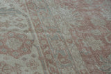 Detail of distressed vintage Sparta carpet, faded dusty rose and ivory floral design.