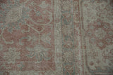 Dusty rose, ivory, and slate floral patterns with visible wear on the vintage Sparta rug.