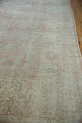 Distressed Turkish Sparta rug with faded dusty rose, ivory floral vine, and serrated border.