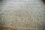 Distressed Sparta carpet corner, serrated leaf border with dusty rose, ivory tones.