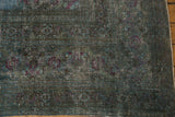 Distressed vintage Khorassan rug's faded teal and violet rose motif with visible foundation.