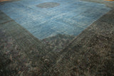 Distressed wide border of the overdyed Khorassan rug, with subtle rose motif in dark teal and violet.