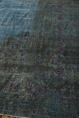 Distressed Khorassan carpet surface in sky blue, teal, and violet rose motifs with wear.