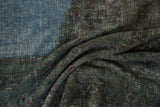 Distressed vintage Khorassan rug showing faded sky blue, teal, violet, and jade pile.