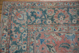 Corner of distressed Mahal carpet shows rose, dusty teal scrolling palmettes, and even wear.