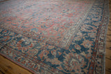 Distressed Mahal carpet's worn dark blue border, dusty rose field, and scrolling vinery.