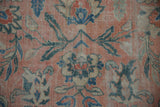 Distressed Mahal rug close-up: rose field with teal vinery and beige palmettes.