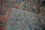 Distressed vintage Mahal carpet with rose and dusty teal palmettes, showing wear and selvage.