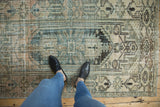 Vintage distressed Hamadan rug showcasing faded teal, apricot, and charcoal geometric patterns.