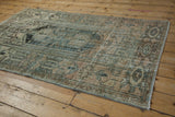 Distressed texture and faded tones on a vintage Hamadan rug corner, showing selvage and fringe.