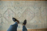 Vintage Serab runner showcasing a faded pink diamond medallion with blue motifs and worn hand-knotted pile.