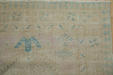Detail of vintage Serab runner with fringe, showing textured pile and faded blue plant motifs.