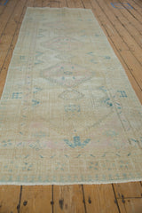 Vintage Serab runner displaying worn triple diamond medallions in faded ivory, pink, and blue.