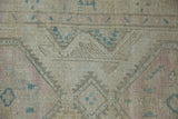 Worn field of vintage Serab runner, showing faded geometric lattice and subtle pink, blue tones.