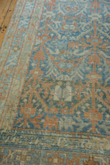 Angled view of a distressed Hamadan runner's low pile with terracotta and blue vinery.