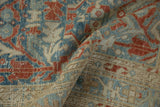 Textured, low pile of a distressed Hamadan rug with floral vinery in blue and terracotta.